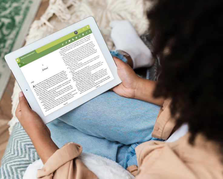 A woman at home, reading a book on Snapplify Reader using a tablet device